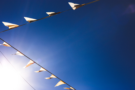 Small yellow flags in the sky with copy space. Natural minimalism, dark geometric pattern with sun spot.の写真素材