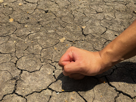 cracked ground and angry fist hand