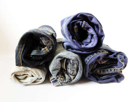 pile of different jeans isolated on white backgroundの写真素材