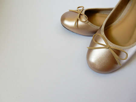 gold flat shoes on white backgroundの写真素材