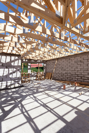 New residential wooden construction home framing. Building a roof with wooden balksの写真素材