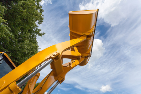Buldozer bucket at construction site against blue sky. の写真素材