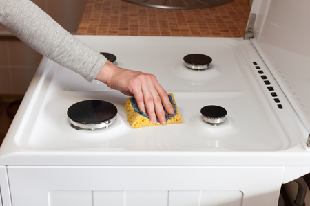 Housewife  hand with a rag clean the dirty gas stoveの写真素材