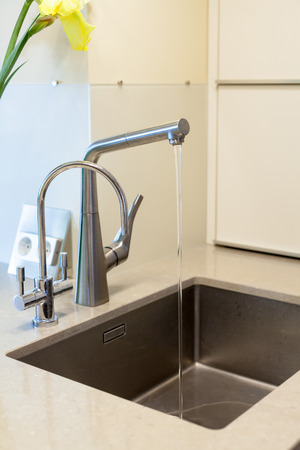 Detail of a rectangular designer kitchen sink with chrome water tapの写真素材