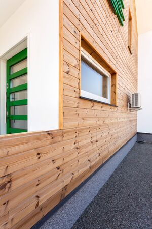 Wooden house with green door and air conditioningの写真素材