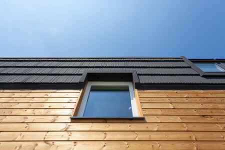 Roof Window on new wooden house against blue skyの写真素材