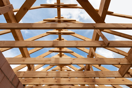 New construction home framing against blue sky, closeup of ceiling frame.の写真素材