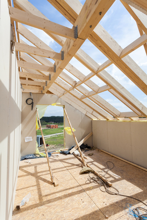 Attic room under construction with gypsum plaster boards. Roofing Construction Indoor. Wooden Roof Frame House Construction.の写真素材