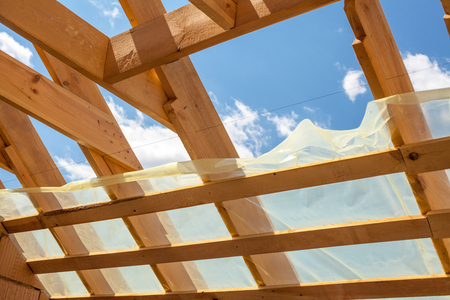 New residential construction home framing against a blue sky. Roofing construction. Wooden constructionの写真素材