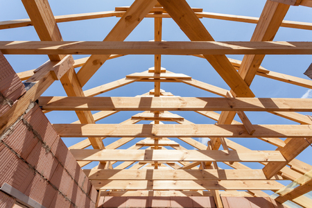 New residential construction home framing against a blue sky. Roofing construction. Wooden constructionの写真素材