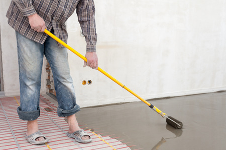 Electric floor heating system installation in new house. Roller for pouring concrete floor.の写真素材