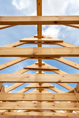 New residential wooden construction home framing against a blue skyの写真素材