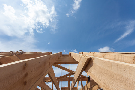 New residential wooden construction home framing against a blue skyの写真素材
