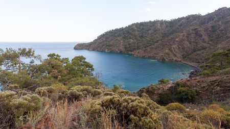 Cove in the clear sea on the background of the rocky mountainsの写真素材