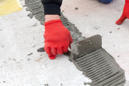 Worker use spatula for plastering a floorの写真素材
