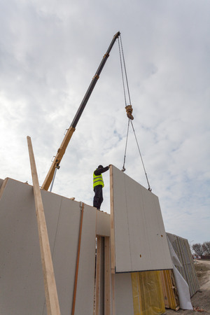 Roofer builder workers with crane installing structural Insulated Panels SIP. Building new frame energy-efficient houseの写真素材