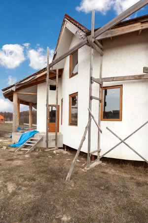 Construction of  adobe house with  thatched roof and plastic windowsの写真素材