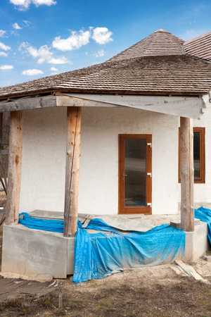 Construction of  adobe house with  thatched roof and plastic windowsの写真素材