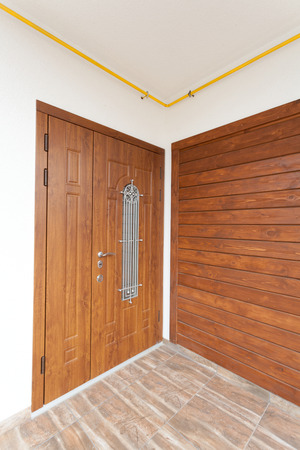 Modern entrance door with brown wooden panelsの写真素材