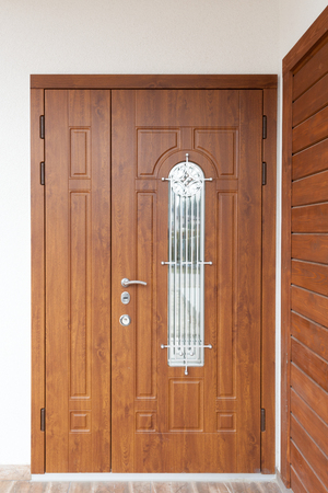 Modern entrance door with brown wooden panelsの写真素材