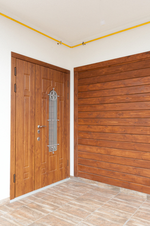 Modern entrance door with brown wooden panelsの写真素材