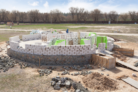 Constraction workers building a roundhouse with aerated autoclaved concrete blocksの写真素材