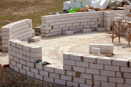 Constraction workers building a roundhouse with aerated autoclaved concrete blocksの写真素材