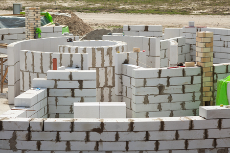 Constraction workers building a roundhouse with aerated autoclaved concrete blocksの写真素材