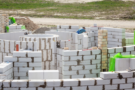 Constraction workers building a roundhouse with aerated autoclaved concrete blocksの写真素材