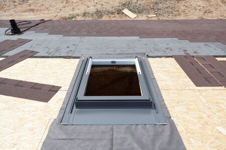 Installing window skylight on a roof with Asphalt Shingles or Bitumen Tiles under constructionの写真素材