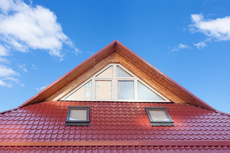 Red Metal tiled Roof with New Dormers, Roof Windows, Skylights and Roof Protection from Snow Boardの写真素材