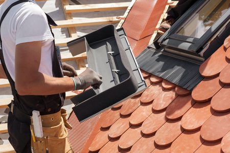 Installation of mansard windows on a new roof of red tilesの写真素材