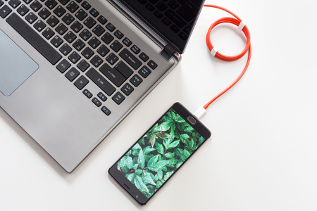 Smartphone is connecting to laptop computer.の写真素材