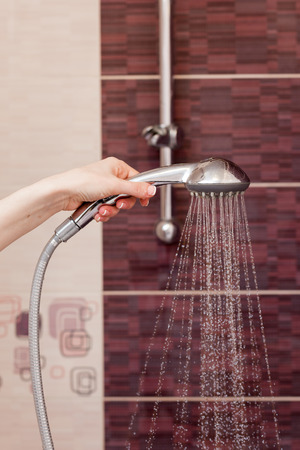 Water streams flow out of working shower head right down.の写真素材