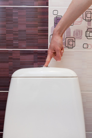 Finger pushing button and flushing toilet.の写真素材