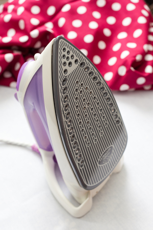 Close-up of electric iron on fabric background.の写真素材