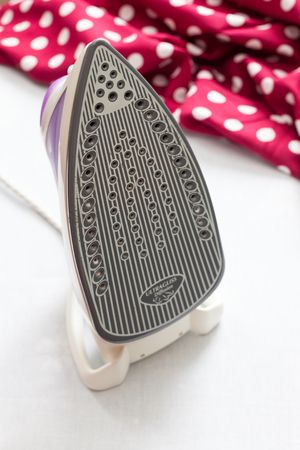 Close-up of electric iron on fabric background.の写真素材