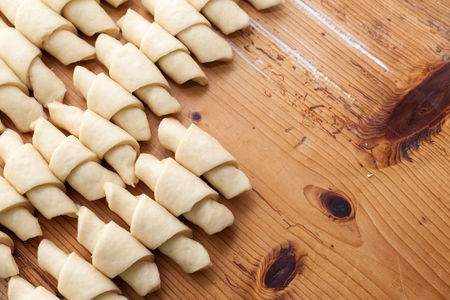 Process of cooking small croissants with cherry for breakfast. Preparation of baking on a rustic wooden background with dusting of flourの写真素材