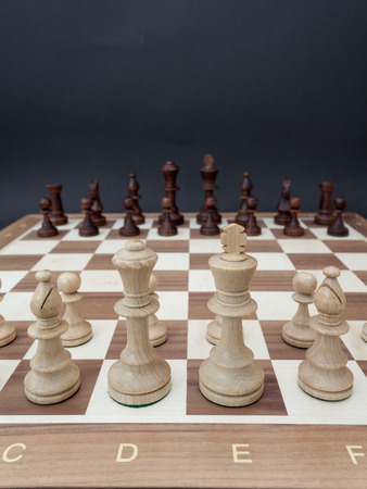 Chessboard with wooden figures placed opposite each otherの写真素材