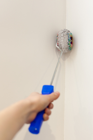 Worker painting wall in room. Painting walls in a corner with a rollerの写真素材
