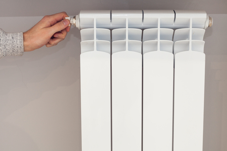Radiator adjustment closeup. Woman's hand adjusting radiator temperature.の写真素材