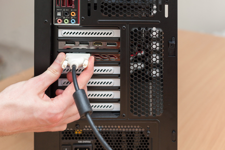 Man hand connecting the DVI cable for monitor to computer PCの写真素材