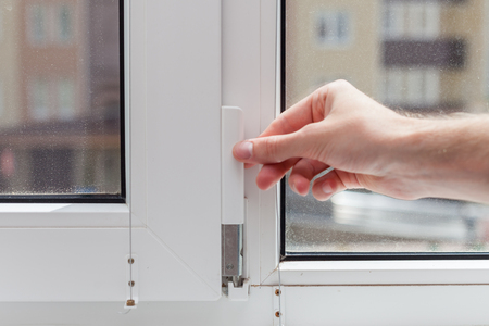 The worker removes the protective plug from the element of the plastic window. Preparing a plastic window for minor repairs.の写真素材