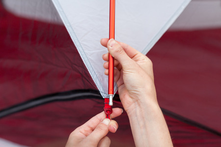 Close up detail of camping tent. Aluminum tent poles. Process of installing tent, setting up tent outdoors.の写真素材