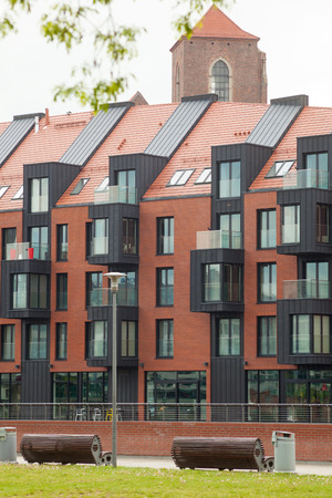 Contemporary Residential Building Exterior in the Daylight with modern balcony and brick facadeの写真素材