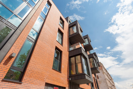 Contemporary Residential Building Exterior in the Daylight with modern balcony and brick facade