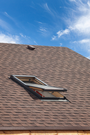 Roof with mansard windows and asphalt shingles.の写真素材