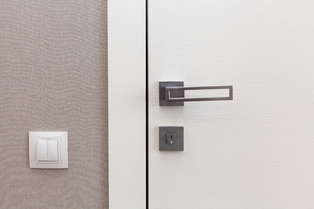 Close white door with metallic handle. The door to the bedroomの写真素材