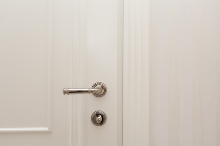 Close white door with metallic handle.の写真素材