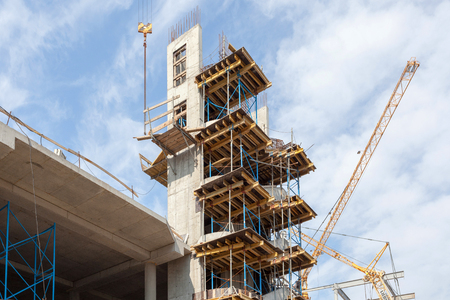 Residental building under construction. Precast concrete stairs installed. Walls made of aerated concrete blocks. Crane and new mutlistoty building construction site. Construction of staircases.の写真素材